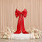 Red satin bow wedding backdrop with floral arrangements and candles