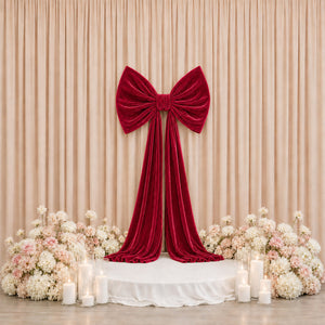 Elegant red velvet bow backdrop with flowers and candles for wedding decor
