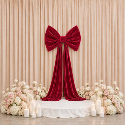Elegant red velvet bow backdrop with flowers and candles for wedding decor