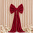 Red velvet bow backdrop with draped tails and white floral decor