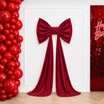 Red velvet bow birthday backdrop with balloons and sequin wall

