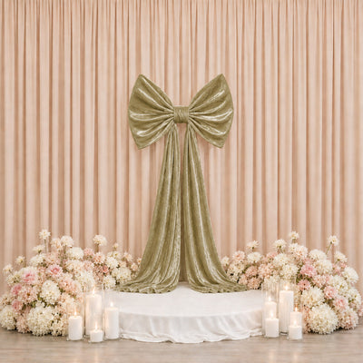Elegant blush floral wedding backdrop with gold velvet bow and candles