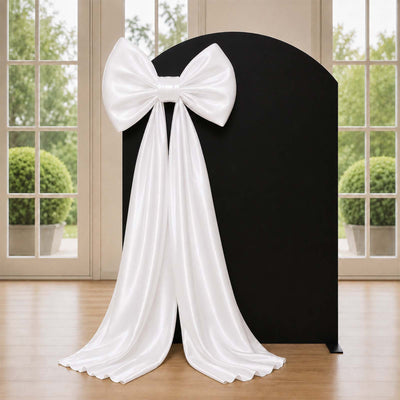 Elegant white satin bow and draped backdrop for wedding or event decor