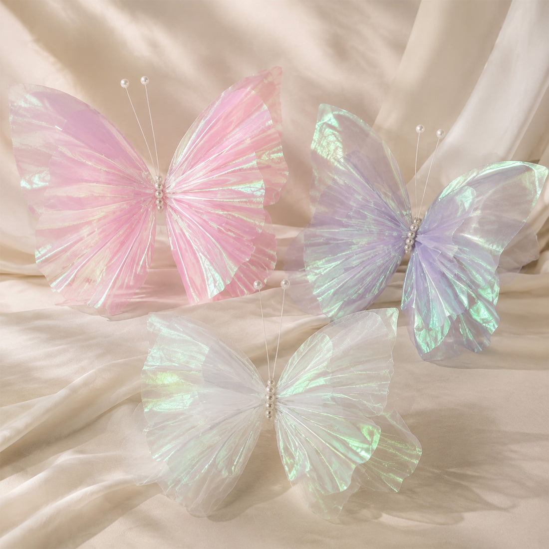 Pastel iridescent butterfly wings on soft beige fabric backdrop