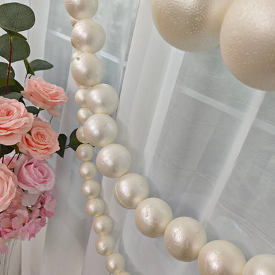 Pink roses and pearl garland wedding backdrop with sheer white curtains