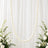 White pearl garland on sheer draped backdrop with elegant white floral arrangement