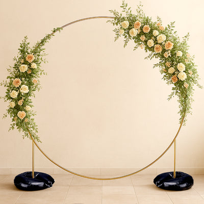 Floral wedding arch with roses and greenery on a neutral background.