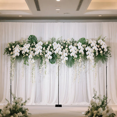 Elegant floral backdrop with white orchids and greenery for events.
