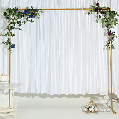 Decorative wedding arch with floral accents on a white backdrop