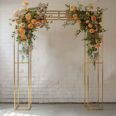 Gold floral arch adorned with orange roses and greenery.