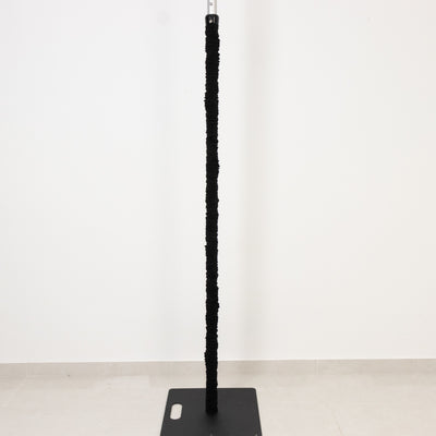 Black cat scratching post on a plain base