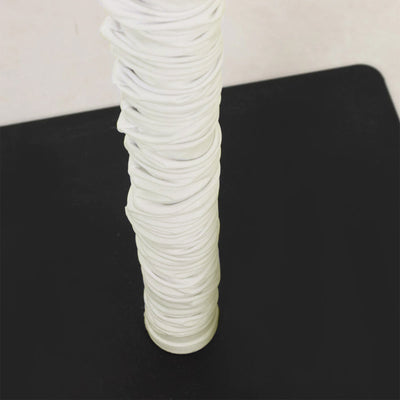 White wrapped cylindrical object on black surface close-up