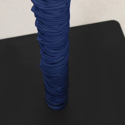 Blue ribbed fabric wrapped around a vertical pole on a black surface