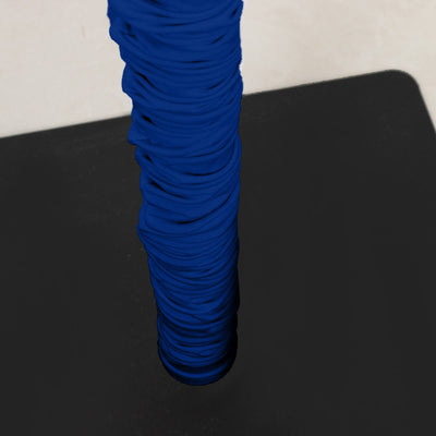 Blue ribbed cylindrical fabric wrap on a black surface, close-up view