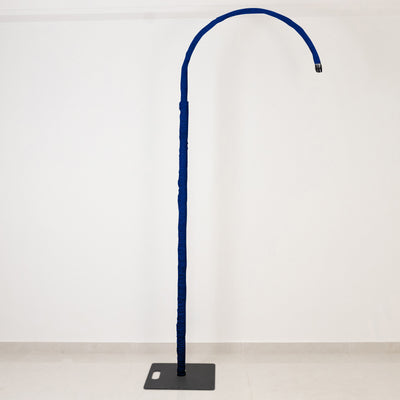 Blue floor-standing gooseneck microphone stand on base against white wall