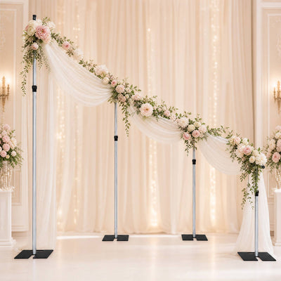 Elegant floral wedding arch with draped fabric in a soft blush ceremony backdrop