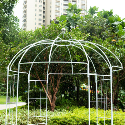 White metal garden gazebo in a lush park setting.