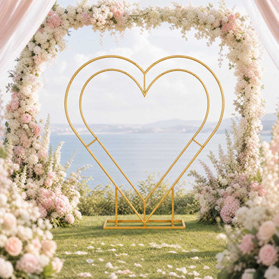 Elegant heart-shaped wedding arch with pink and white floral decor by the sea