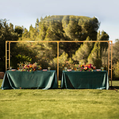 Decorative outdoor dining setup with green tables and floral arrangements.