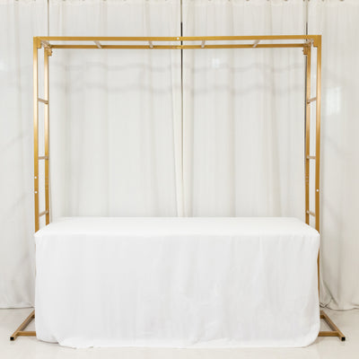 Gold wedding arch frame with white tablecloth below