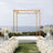 Elegant gold wedding arch set against a scenic ocean backdrop.