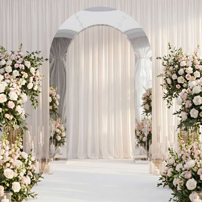Elegant wedding ceremony arch with white drapery and pastel floral arrangements