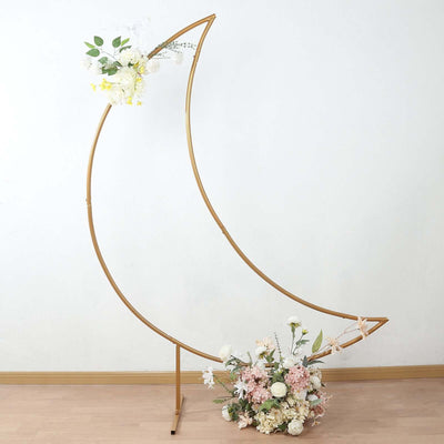 Gold moon-shaped flower stand with white and pink floral arrangement
