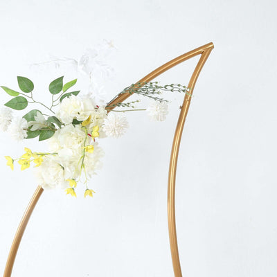 Gold floral arch with white and yellow flowers on a plain backdrop