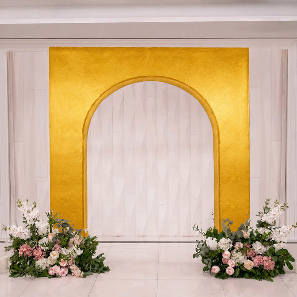 Gold arch wedding backdrop with white curtains and floral arrangements