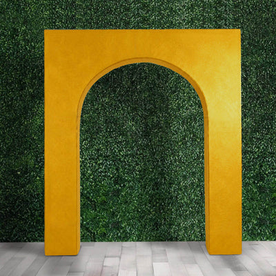 Golden arch frame against green hedge wall and gray floor backdrop