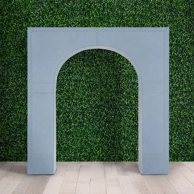 Modern arch backdrop with green hedge wall and light wood floor