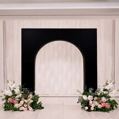 Elegant wedding backdrop with black arch and pastel floral arrangements