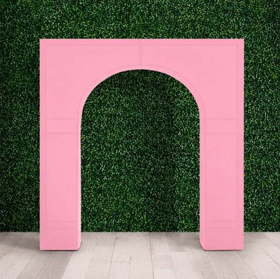 Pink inflatable arch against green hedge backdrop indoors