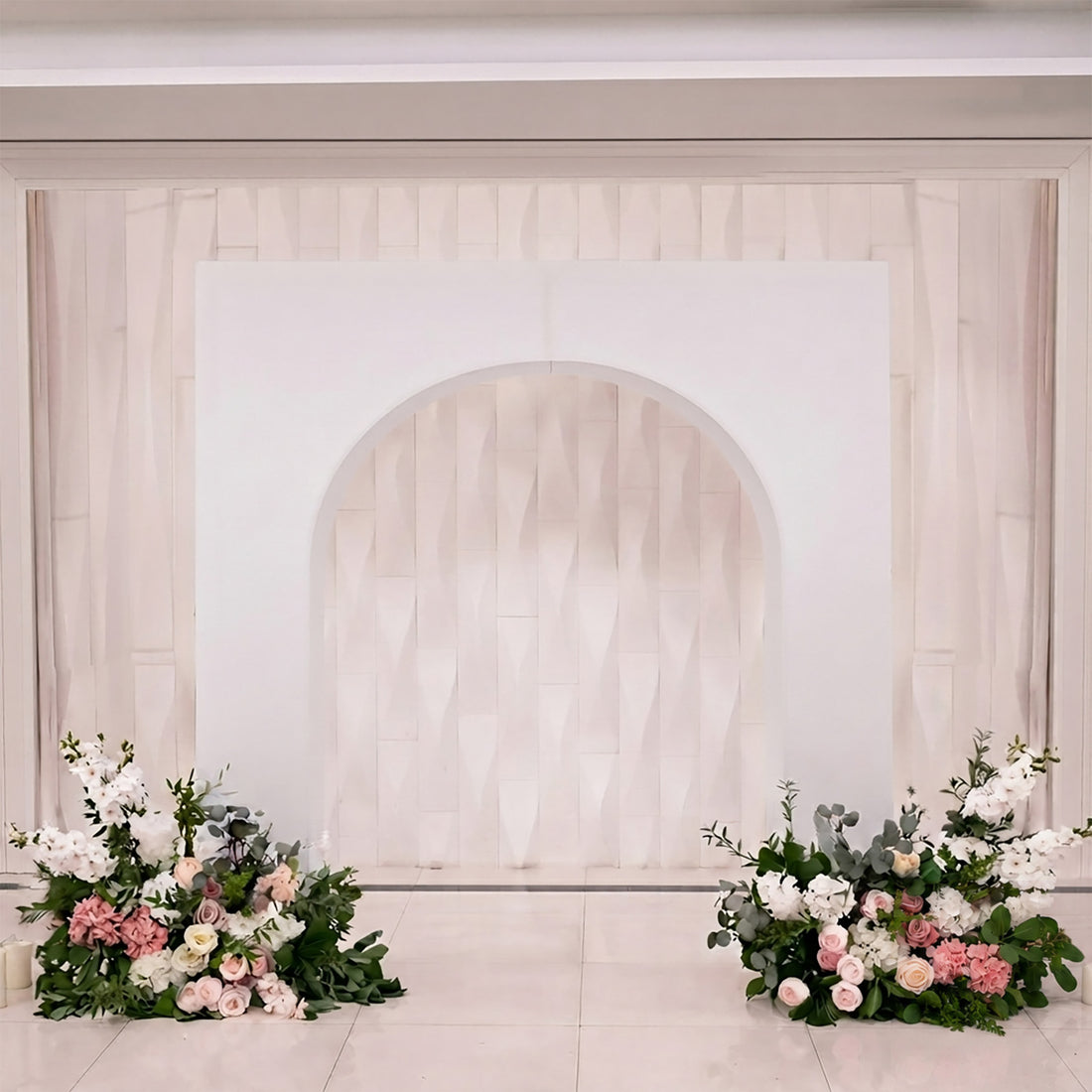 Elegant wedding stage backdrop with floral arrangements and blush roses