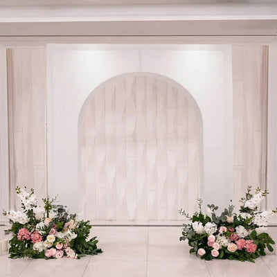 Elegant wedding backdrop with white arch and pink floral arrangements