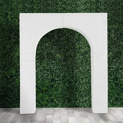 White arched decorative backdrop against green hedge wall and gray floor