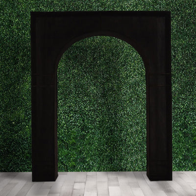 Black archway against a green foliage backdrop, enhancing outdoor decor.