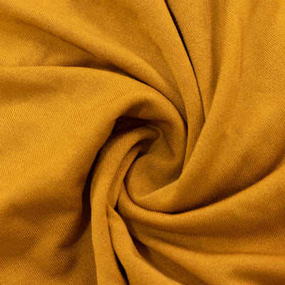 Mustard yellow fabric texture in a swirling pattern.