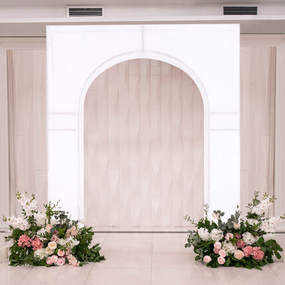 Elegant wedding backdrop with floral arrangements in soft pink and white.