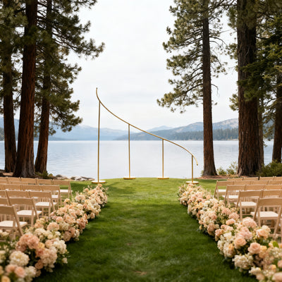 Elegant wedding ceremony setup by the lake, adorned with flowers and chairs.