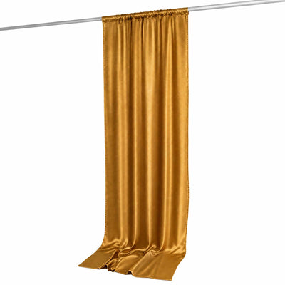 Gold satin curtain panel hanging on a rod with elegant draped folds