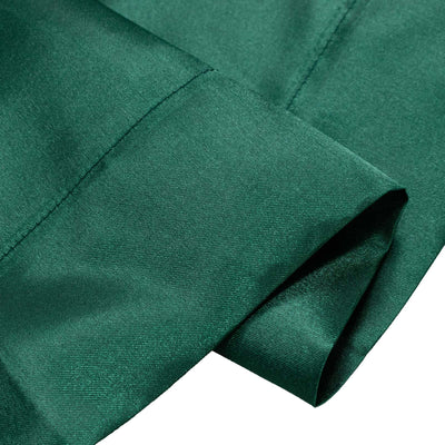 Close-up of emerald green woven fabric with stitched seam and folded edge