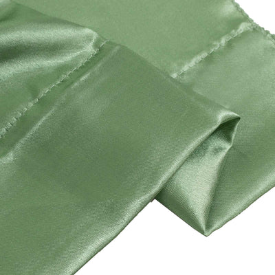 Green satin fabric close-up with folded texture and stitched seams