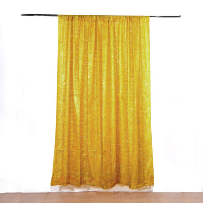 Shimmering gold curtain draped from a black rod against a white background