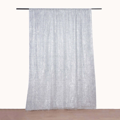 Sheer silver curtain draped from a black rod against a plain backdrop