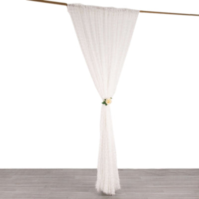 White sheer curtain with floral tieback hanging elegantly.