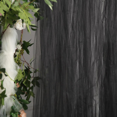 Black tulle fabric draped with greenery and flowers