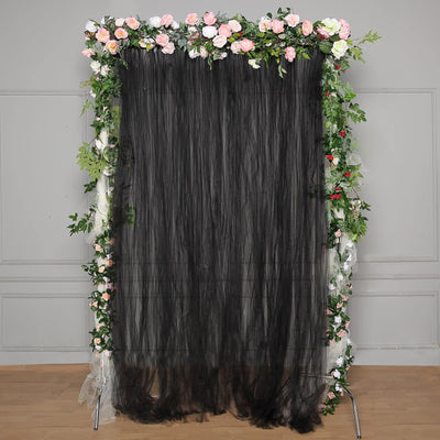 Black tulle backdrop adorned with pink and white floral accents.