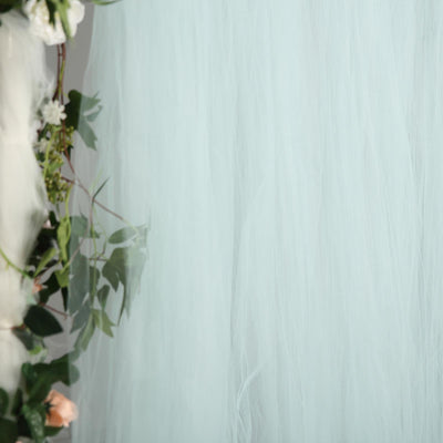 Soft mint green tulle fabric draped with floral accents.