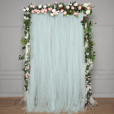 Floral backdrop with light blue tulle and greenery for events and photography.